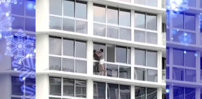 Mujer se pone en peligro al limpiar ventanas de edificio